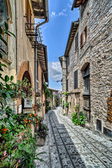 Fototapeta na wymiar Town of Spello, Umbria, Italy. Characteristic narrow cobbled street flanked by houses of medieval origin.