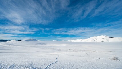 Awe-inspiring view of the snow-covered mountain range in Castelluccio di Norcia, Italy