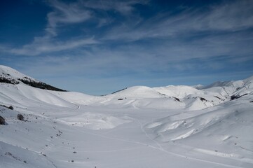 Fototapeta na wymiar Snowy white landscape of mountains in Castelluccio di Norcia in wintertime