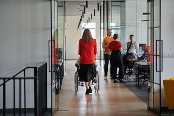 Fototapeta premium A group of young business people in a modern glass-walled office captures the essence of diversity and collaboration, while two colleagues, including an African American businessman in a wheelchair