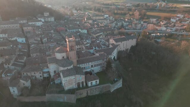 Drone footage over the medieval Comune of Mondaino, Rimini province, Marche, Italy at sunset