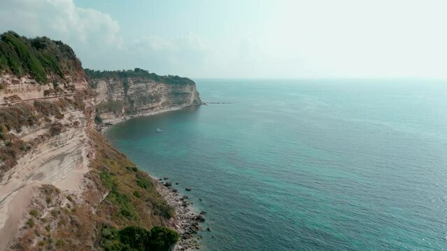 Landscape scene of the cliff by an emerald crystal clear Caribbean sea in the Calabria region, Italy
