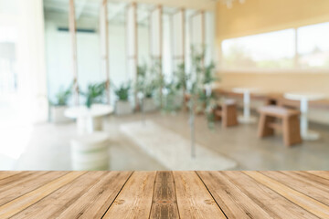 Fondo de cafetería desenfocado con tabla de madera para servir bebidas o comida. Local gastronómico.  © SirArbusto
