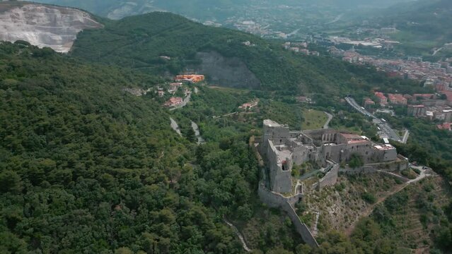 Drone shot over Arechi Castle on a green forested hill
