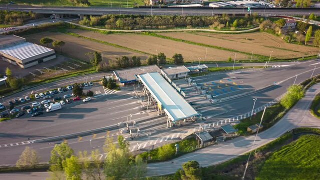 Drone time lapse of cars passing a security gate with lawn around