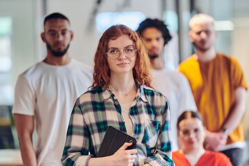 A diverse group of business people walking a corridor in the glass-enclosed office of a modern startup, including a person in a wheelchair and a woman wearing a hijab, showing a dynamic mix of