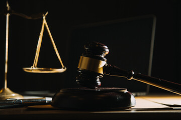 law legal technology concept. judge gavel on computer with scales of justice on desk of lawyer.