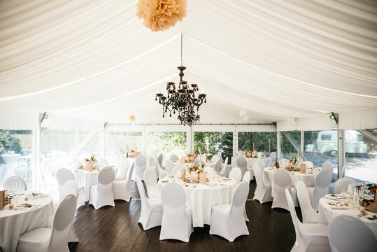 a large banquet tent filled with tables covered in white cloth