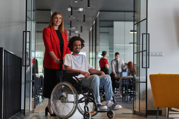 A group of young business people in a modern glass-walled office captures the essence of diversity and collaboration, while two colleagues, including an African American businessman in a wheelchair