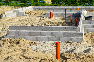 Building the foundation of the house from concrete blocks and installation of pipework system