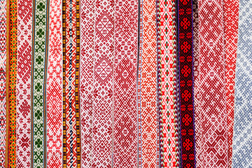 Traditional colorful handmade woven Baltic national patterned fabric belts background