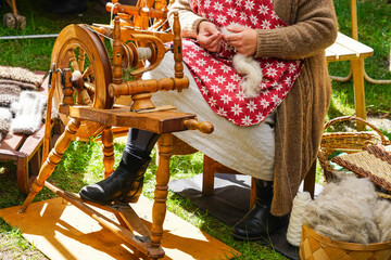 Authentic old wooden spinning wheel in action, full yarn basket