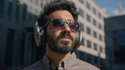 Carefree Indian Arabian businessman business man student wear sunglasses listen music sunny...