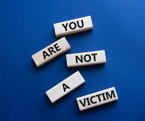 You are not your a victim. Wooden blocks with words You are not a victim. Beautiful deep blue background. Business and You are not a victim. Copy space.