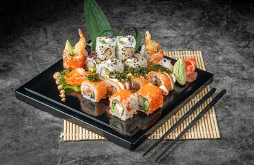 Overhead view of a black plate with a delicious selection of sushi