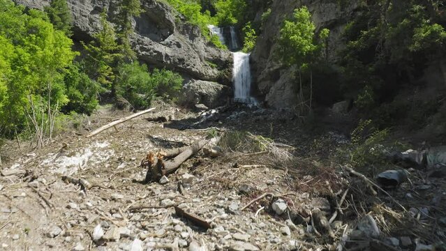 Wide aerial drone view of avalanche debris, damage at base of Upper Falls Utah