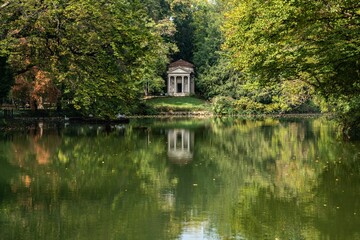 Beautiful classic structure on the lakeside surrounded by lush greenery in the park of Monza. Italy.