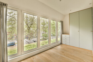 an empty room with wood flooring and sliding glass doors that open to the street in front of the house