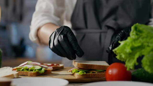 Breakfast, fast food master adding red tomato sauce in a takeaway restaurant. Smooth camera movement sandwich cook combines ingredients follows modern principles of healthy food, kitchen