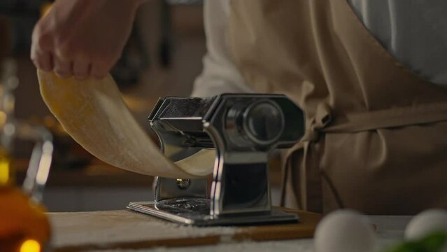 Tool, professional chef prepares Rolls out dough for cooking pasta in a takeaway food restaurant. General view Manual pasta master Dough rolling follows the modern principles of healthy food industry