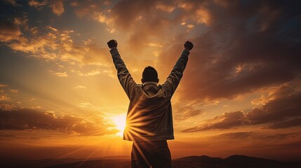 Fototapeta premium Young man raises his hands at sunset. silhouette concept