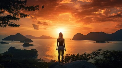 Obraz premium During sunset a European girl enjoys a breathtaking view of the bay and Koh Kradan from Koh Mook mountain. silhouette concept
