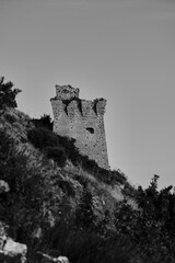 Obraz premium Vertical of an old castle on a hill in South Italy in grayscale