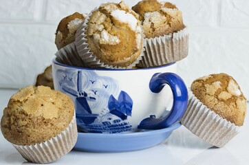 muffins in a bowl are arranged next to cupcakes