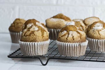 a wire rack holding twelve muffins sitting on top of a table