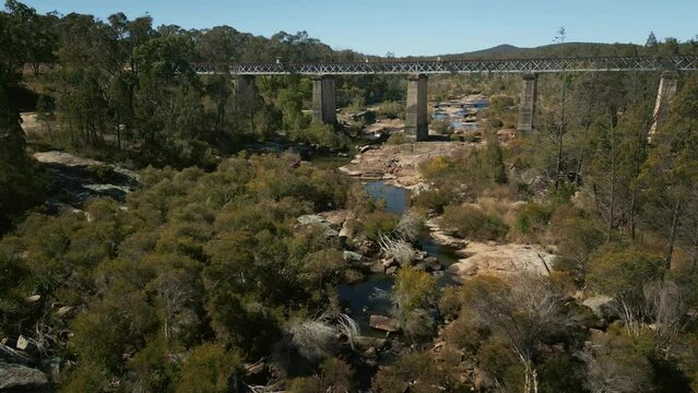 Drone footage over the Quart Pot Creek Rail Bridge with forest trees in Stanthorpe, Australia
