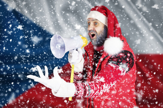 Santa Claus shouts into a megaphone and shows a hand gesture against the background of the flag of Czech Republic