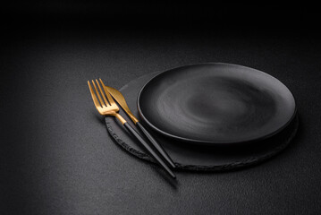 Empty black plate over dark stone background with copy space