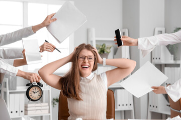 Stressed young businesswoman working under deadline in office