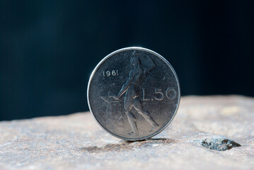 Closeup of  a silver 1 Dollar 1994 Hong Kong on the rocky surface with a dark background