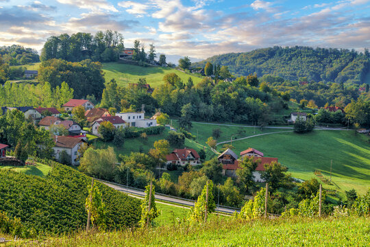 Slovenian countryside agricultural  landscape. Vineyard, meadows, fields and green mountains, the village at the foot of the mountain. 