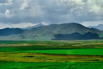 Aerial view of a stunning, landscape dotted with clouds, with lush green mountains in the background