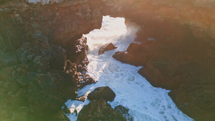 Rough ocean rocky coast washing by foamy bubbling water in super slow motion.