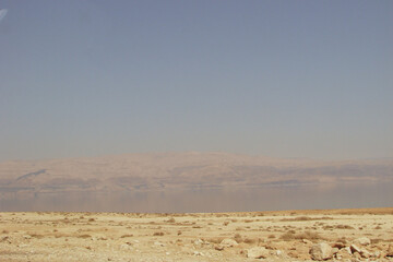 Environment with wild desert nature, dry hot sand and rocks in the background. Natural, not man-made landscape.