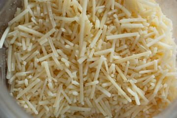 A top down view of shredded parmesan cheese inside a container.