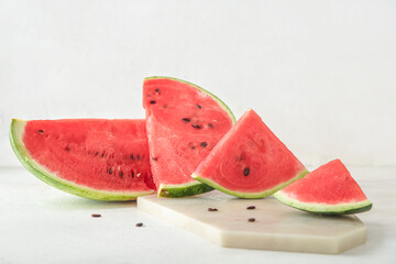 Board with pieces of ripe fresh watermelon on light background, closeup