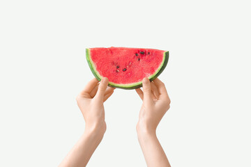 Female hands with piece of ripe watermelon on white background