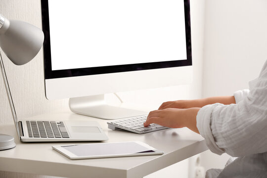 Female programmer typing on computer keyboard at her workplace in office, closeup