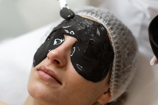 Black peeling mask on face of woman