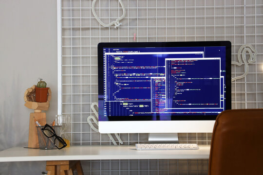 Computer monitor with code at programmer's workplace in office