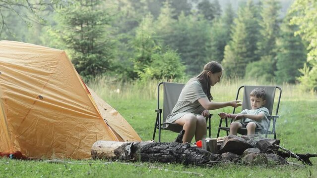 Mother uses a remedy for mosquitoes and biting insects in nature for son. Protection of the skin from tick bites, gadflies, blood-sucking pests, a means for children without allergens for outdoor camp
