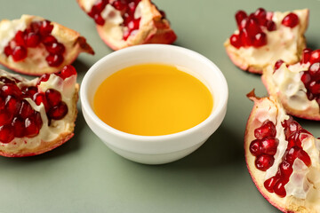 Bowl of honey and pomegranate for Rosh Hashanah celebration (Jewish New Year) on grey background