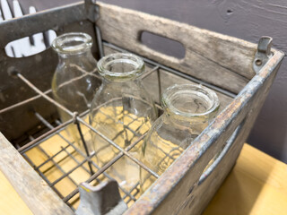 A view of glass milk bottles in a delivery crate.