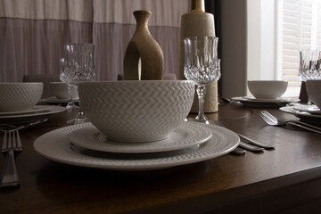 A view of a styled home dining table with place settings.