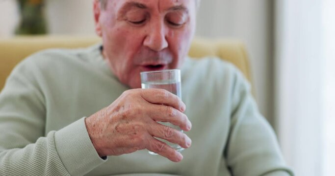 Senior man, drinking water and Parkinson disease or tremor with trembling hands on a home sofa. Sick elderly person with a disability, glass and neurology, muscle or shaking illness in retirement