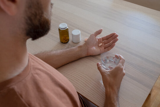 An anonymous male model is taking medications and supplements at home.
